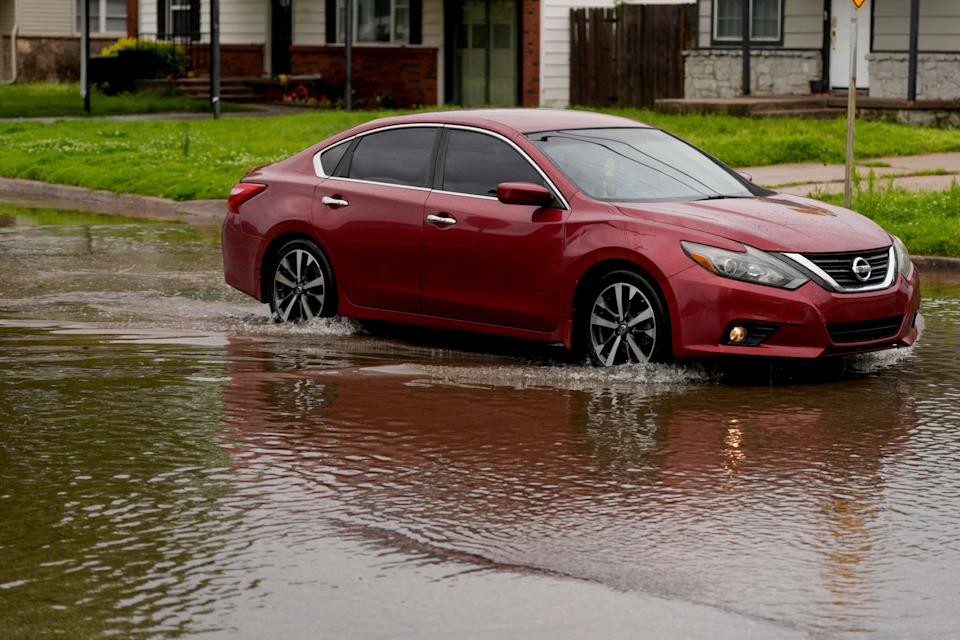 A vehicle is driven through high water April 30 at the intersection of NW 35th Street and North Hammond Avenue in Warr Acres.