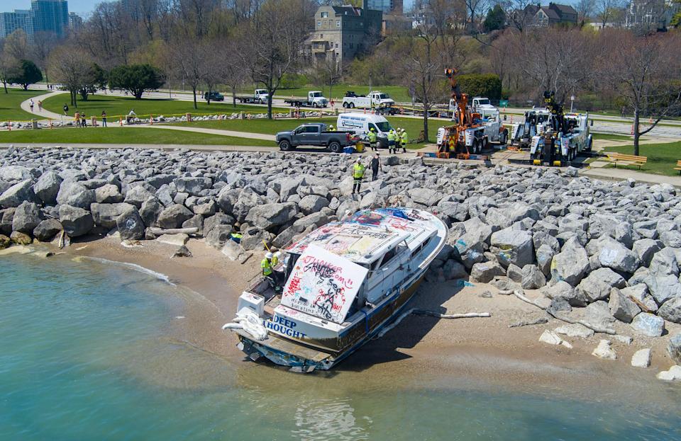 Work is done to remove the abandoned boat "Deep Thought" from the shoreline of Lake Michigan near Bradford Beach in Milwaukee on Tuesday, May 6, 2025. The boat has been stuck since October after its Mississippi-based owners ran out of gas while operating it.