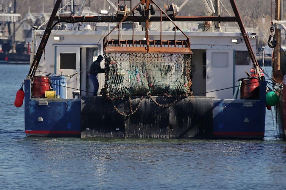 Fishermen make repairs to the dredge of a scallop fishing boat docked in New Bedford.