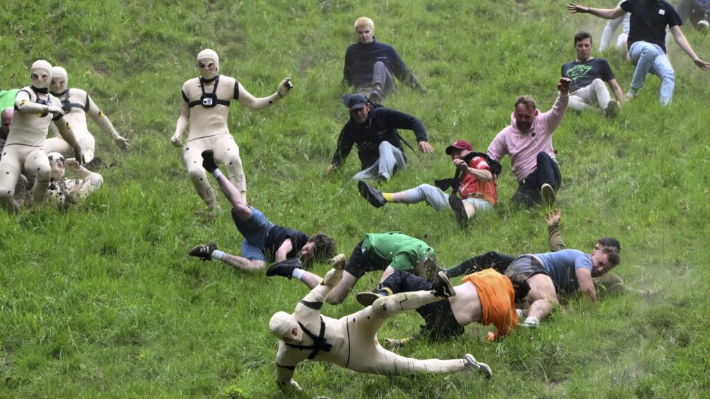 AP PHOTOS: Runners trip, stumble and roll their way to victory in annual downhill cheese chase