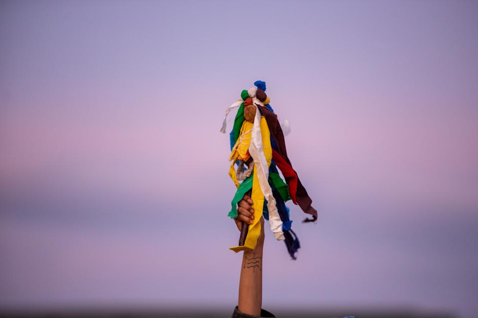 Ta Pejuta Wichahpi Win holds up a prayer stick as Red Lake Drum Group plays during a vigil honoring Rep. Melissa Hortman and her husband Mark Hortman outside of the Minnesota State Capitol Wednesday, June 18, 2025 in St. Paul. (Photo by Nicole Neri for the Minnesota Reformer)