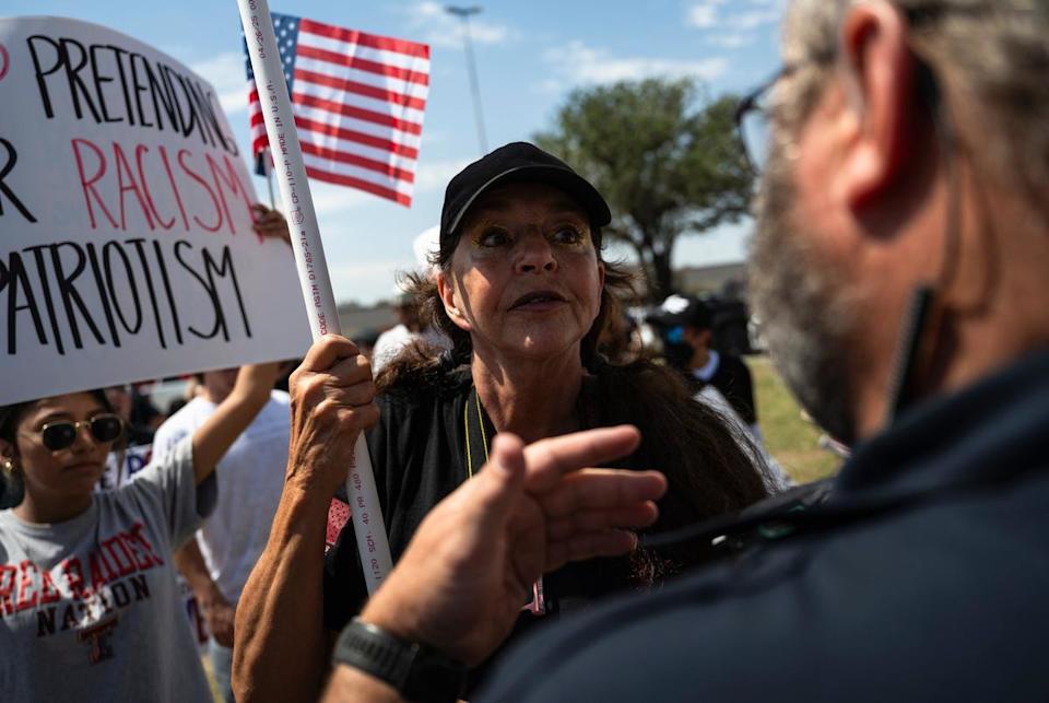 An Odessa Police Department officer, right, confronts a counter protestor as she walks through a crowd of No Kings Day demonstrators after jaywalking through a busy intersection on Saturday, June 14, 2025, in Odessa.