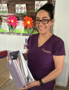Liliana Vazquez Diaz, who runs the family child care center La Casa de Lily out of her home, shows the binder of paperwork she completed to receive a higher child care rating, which resulted in more money from the state per child. (Rebecca Gale)