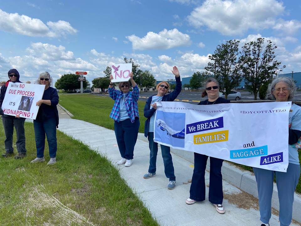 Protesters wave to cars on Dupont Highway outside of Wilmington Airport near New Castle on May 31, 2025.