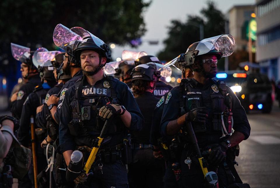 Austin Police officers in riot gear keep anti-President Donald Trump demonstrators from the JJ Pickle Federal Building after the No Kings demonstration in Austin on June 14, 2025.